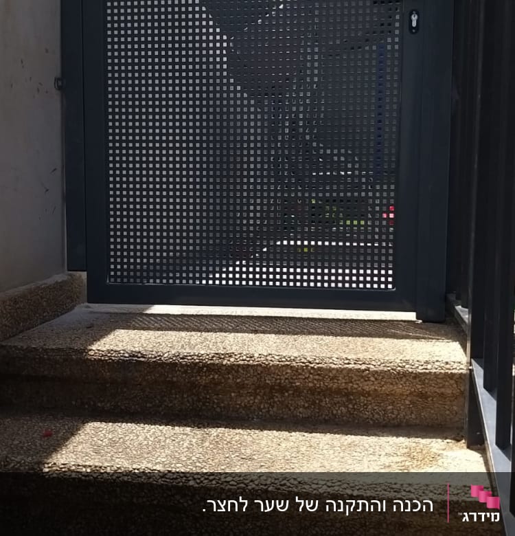 שער מתכת עם חורים מרובעים על מדרגות